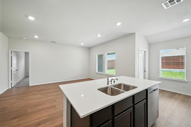 Kitchen with dishwasher, light wood-style floors, light countertops, a kitchen island with sink, and open floor plan | Image 9