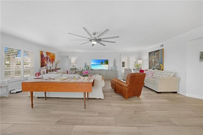 Living room with ceiling fan and ornamental molding | Image 12