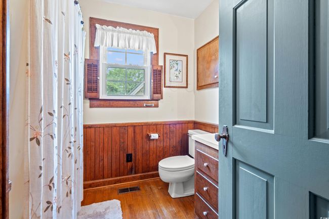 Full bath with wood finished floors, a wainscoted wall, vanity, and wood walls | Image 15