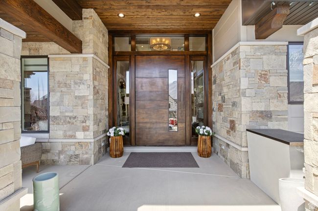 View of exterior entry with stone siding and covered porch | Image 7