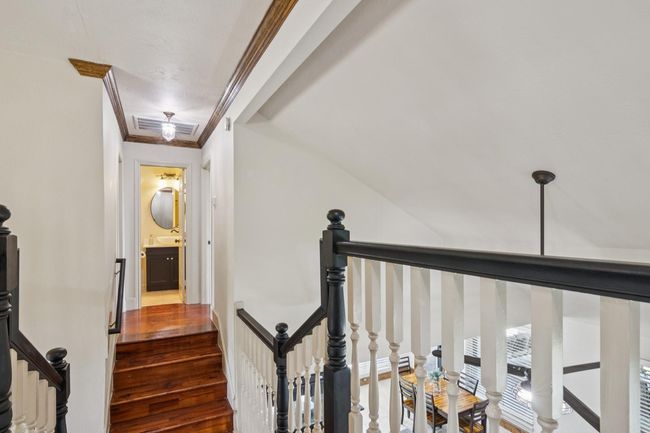 Stairs are split at the top with bedrooms 3 & 4 and a bath to the left and the 5th bedroom with attached bath on the right. | Image 33