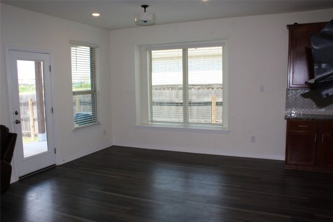 Unfurnished dining area with dark wood-style flooring, baseboards, and recessed lighting | Image 4