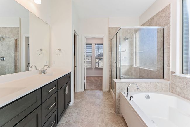 Full bathroom featuring a sink, double vanity, a bath, and a shower stall | Image 12