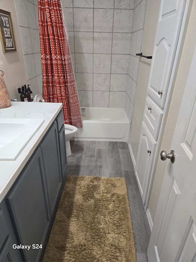 Bathroom with vanity, toilet, and shower / bath combo | Image 16