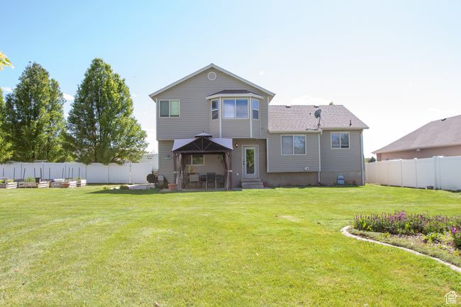 Rear view of property featuring entry steps and a patio area with shade gazebo | Image 30