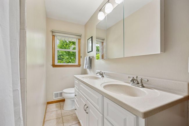 The updated main floor bath with double sinks | Image 20