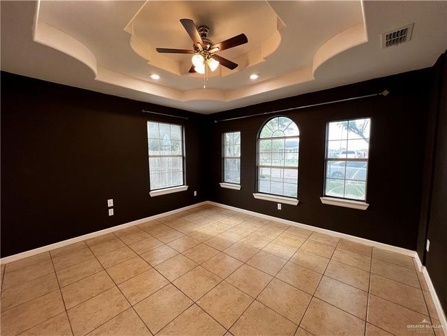 Spare room featuring light tile patterned floors, a tray ceiling, a ceiling fan, recessed lighting, and baseboards | Image 9