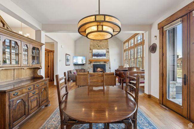 Dining space with baseboards, a fireplace, vaulted ceiling, and light wood finished floors | Image 7