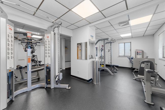 Workout area featuring baseboards, visible vents, and a drop ceiling | Image 28