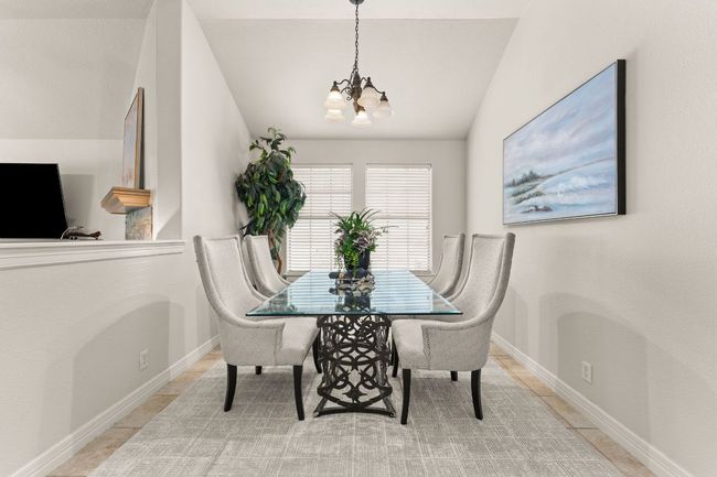 Dining room featuring a chandelier, lofted ceiling, baseboards, and light tile patterned floors | Image 4