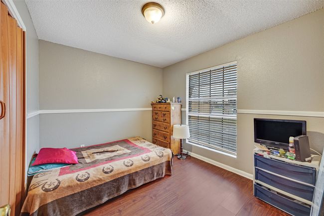 Unit B Bedroom featuring a textured ceiling and dark wood-type flooring | Image 23