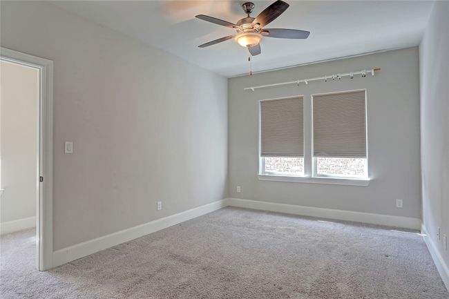Carpeted empty room featuring baseboards and a ceiling fan | Image 21