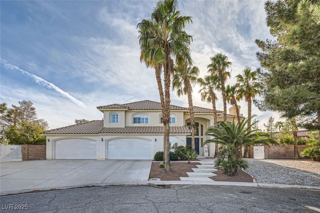 Mediterranean / spanish-style house featuring a garage, concrete driveway, a gate, fence, and stucco siding | Image 18