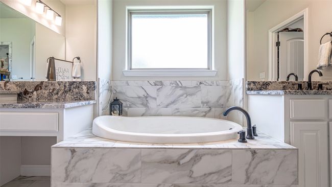 Primary bath featuring separate vanities & garden tub | Image 15