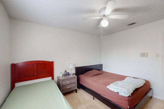 Bedroom with a textured ceiling, ceiling fan, and visible vents | Image 21