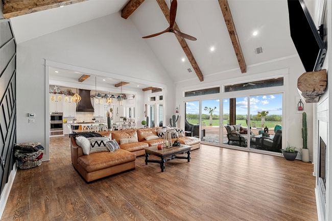 Living area featuring high vaulted ceiling, ceiling fan, visible vents, and beamed ceiling | Image 17