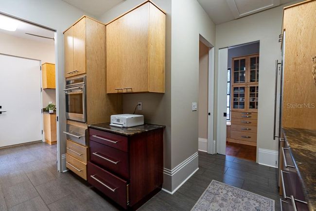The L-shape design of the Butler's pantry includes a spacious pre area, one of two guest-accessible half batha, and can be fully closed off with substantial pocket doors for added privacy and functionality. | Image 27