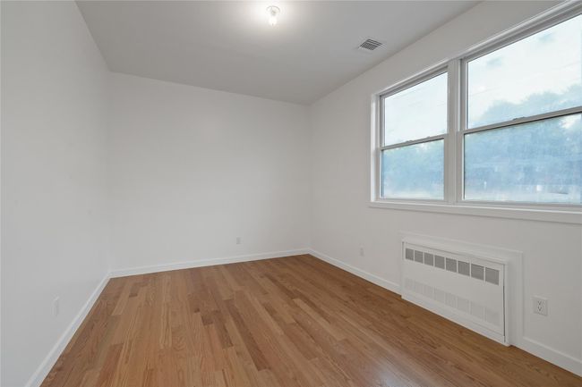 Empty room featuring radiator, light wood-style flooring, and baseboards | Image 30