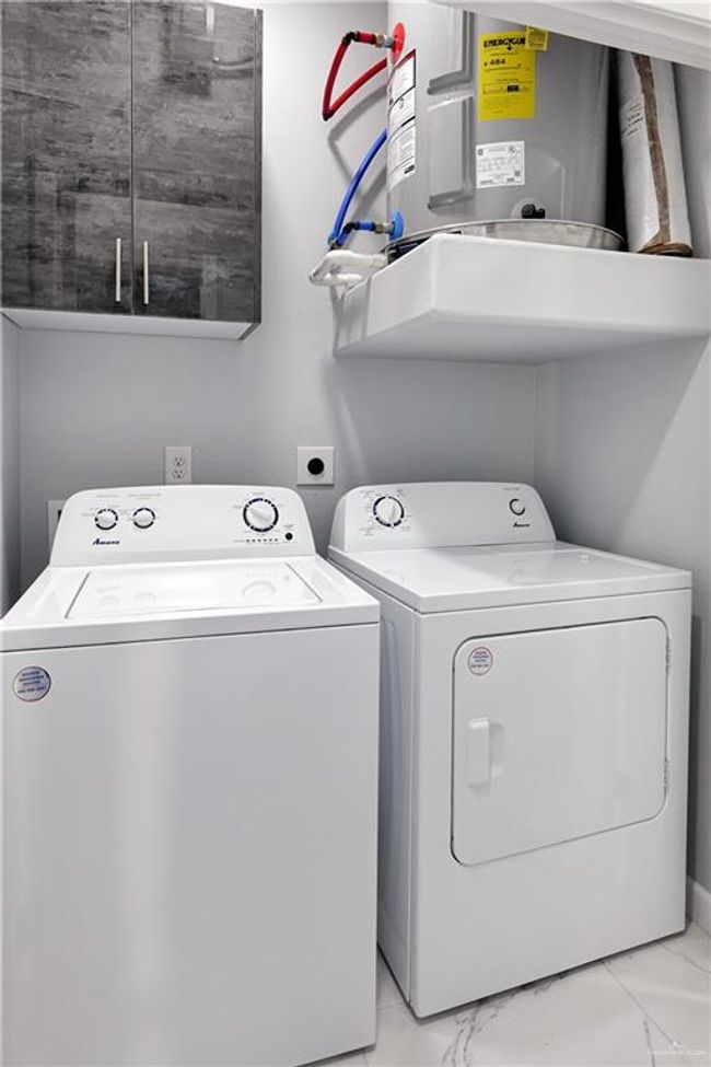 Laundry area with marble finish floor, independent washer and dryer, and cabinet space | Image 9