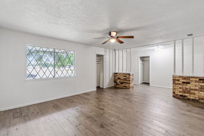 Unfurnished living room featuring a ceiling fan, a textured ceiling, and wood finished floors | Image 5