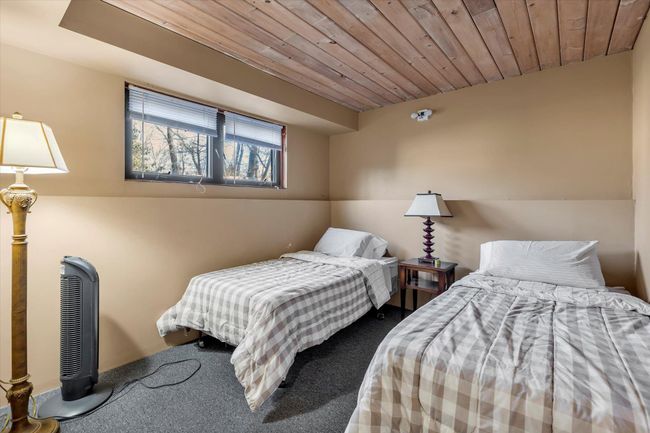 Bedroom with carpet floors and wooden ceiling | Image 24