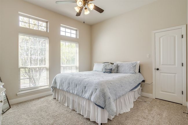 Bedroom featuring ceiling fan, light colored carpet, and baseboards | Image 23