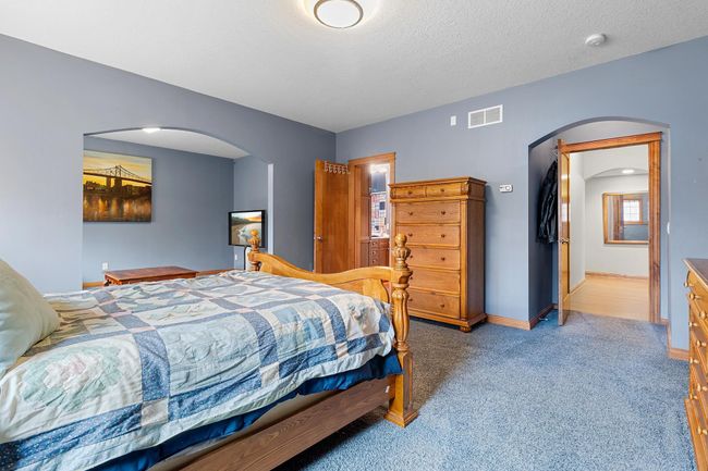 Lower-level first bedroom suite open to separate sitting area and full en-suite bathroom and walk-in closet. | Image 50