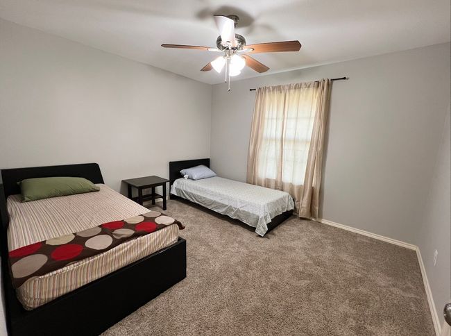 Carpeted bedroom with a ceiling fan and baseboards | Image 9
