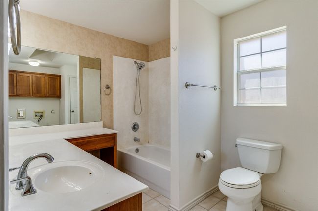 Bathroom with tile patterned floors, toilet, baseboards, bathtub / shower combination, and vanity | Image 20