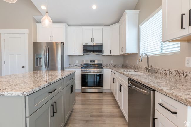 Kitchen with appliances with stainless steel finishes, recessed lighting, plenty of natural light, light wood-type flooring, and white cabinets | Image 5