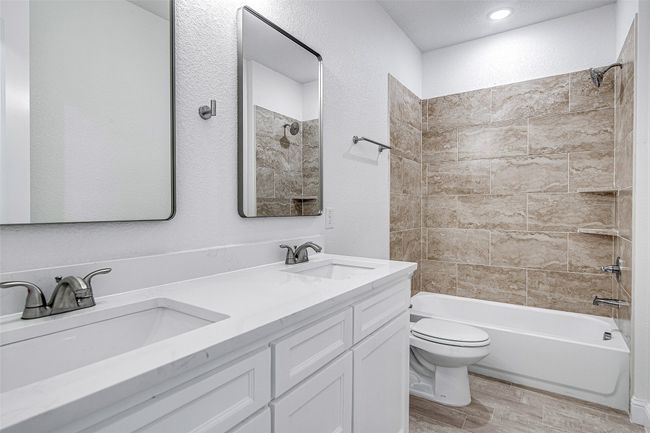 Full bathroom with wood finished floors, toilet, shower / tub combination, and double vanity | Image 19