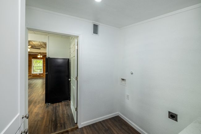 Laundry area featuring baseboards, electric dryer hookup, dark wood-style floors, visible vents, and laundry area | Image 23