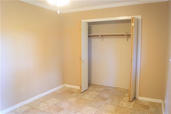 Unfurnished bedroom with crown molding and a closet | Image 7