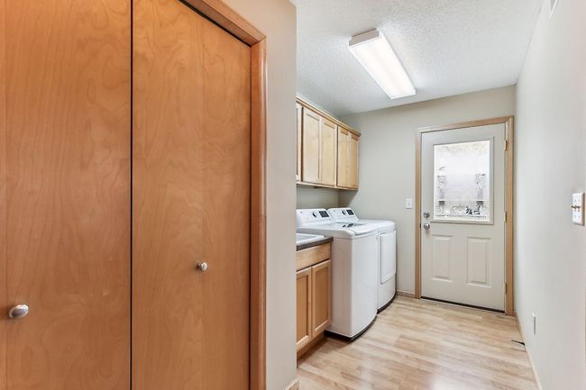 Coming from the garage you'll find this large closet, laundry, and back door. Built-in laundry tub and cabinets. | Image 10