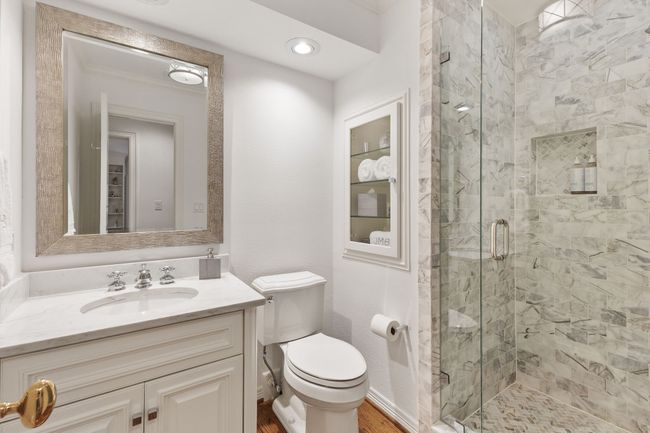 Elegant updated upstairs bath with walk in tiled shower with frameless glass. | Image 24