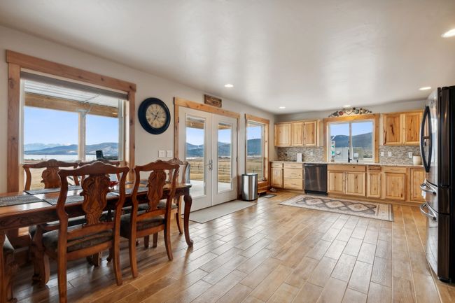 Kitchen with dishwasher, black refrigerator, light wood-type flooring, a mountain view, and backsplash | Image 28