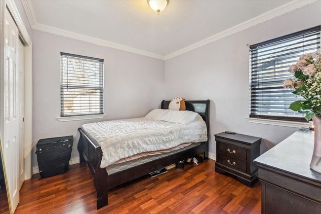 Bedroom featuring a closet, dark wood-style floors, baseboards, and ornamental molding | Image 14