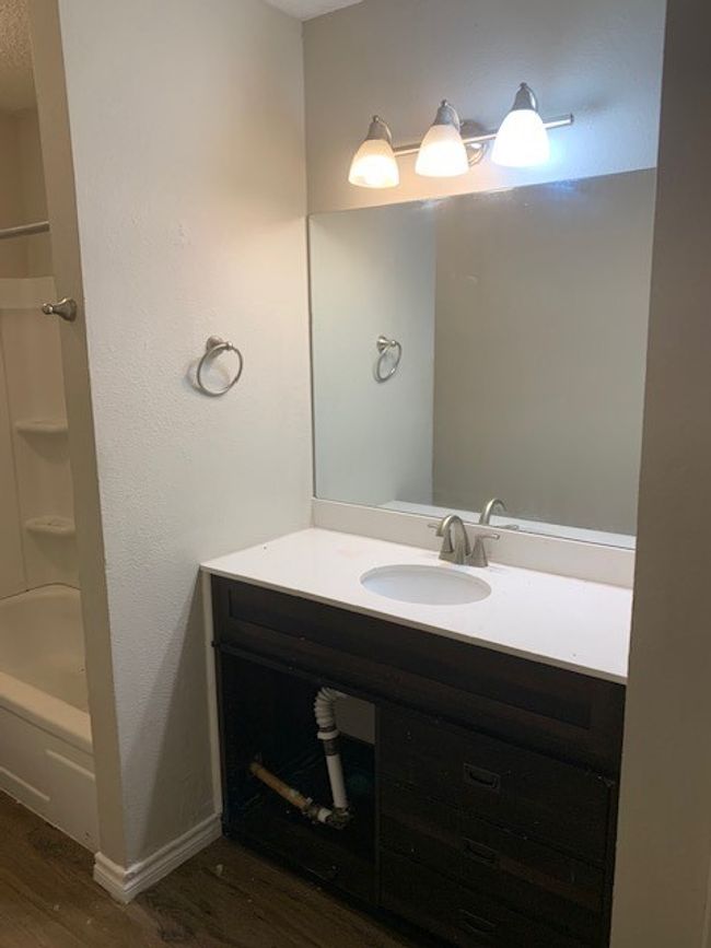 Full bath featuring wood finished floors, vanity, baseboards, and bathtub / shower combination | Image 11