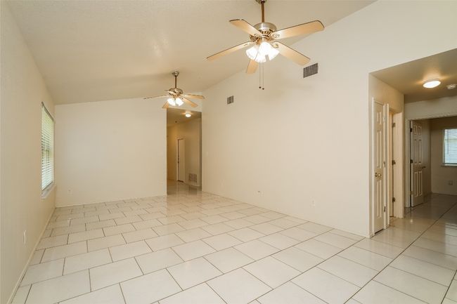 Spare room with ceiling fan, lofted ceiling, and light tile patterned floors | Image 7
