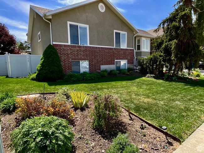 Additional front yard view with perennials throughout, and there is a man gate access to backyard | Image 40