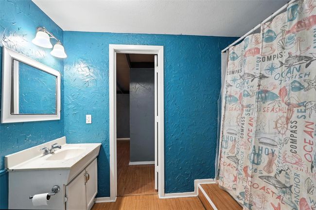 Full bath with wood finished floors, a textured wall, vanity, and curtained shower | Image 22