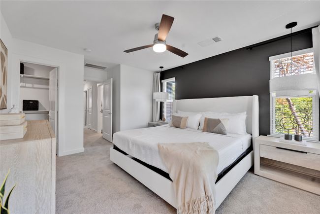 Bedroom featuring multiple windows, visible vents, and light colored carpet | Image 17