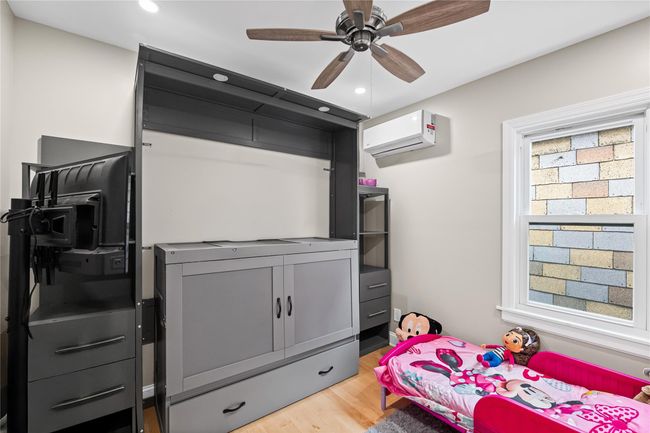 Bedroom with a wall mounted air conditioner, light wood-style floors, recessed lighting, multiple windows, and ceiling fan | Image 25