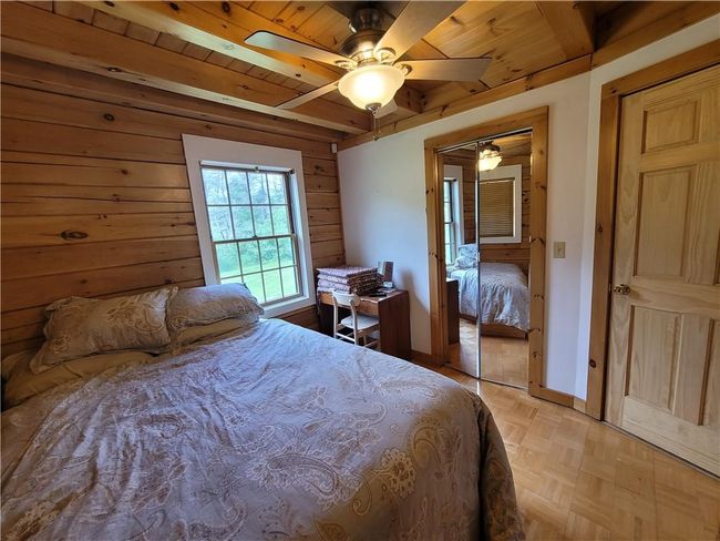Bedroom featuring wooden ceiling, a closet, ceiling fan, and light parquet flooring | Image 15