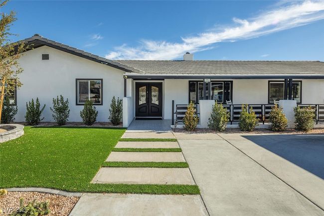 View of front of home with stucco siding, a front lawn, a porch, french doors, and a chimney | Image 4
