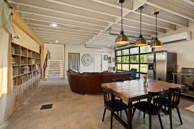 Dining space with concrete flooring, a wall mounted AC, and stairs | Image 20