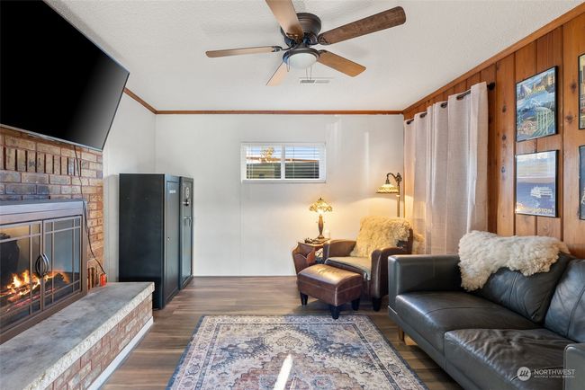 The lower level offers two versatile living spaces, each with its own unique appeal. One area features a cozy fireplace, creating a warm and inviting spot to unwind, while the other provides convenient access to the outdoors through a private door, perfect for seamless indoor-outdoor living | Image 14