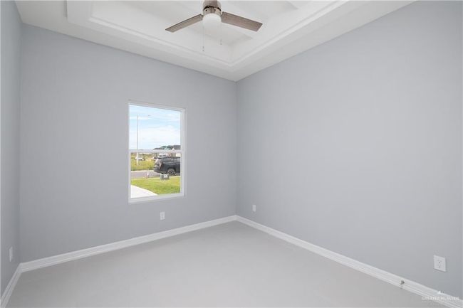 Empty room featuring a tray ceiling and ceiling fan | Image 10