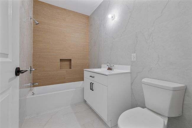 Full bath with marble finish floor, toilet, vanity, and tile walls | Image 44