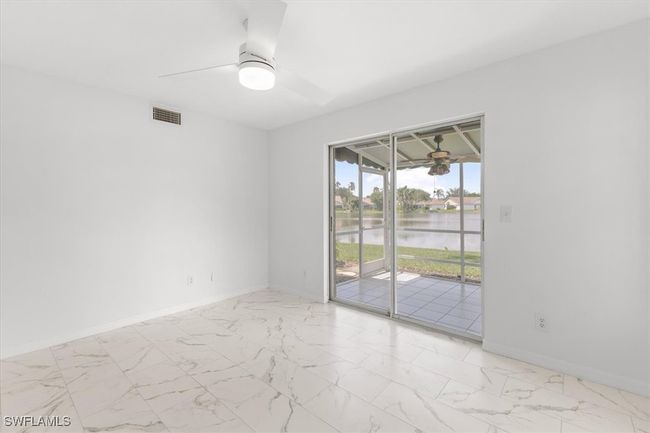 Spare room featuring light tile patterned floors, ceiling fan, and a water view | Image 14